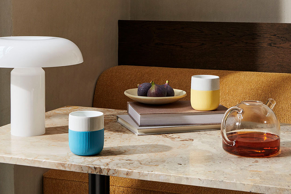 The two Fluted Contrast news from 2022 in blue and yellow standing on a table with some books and a teapot
